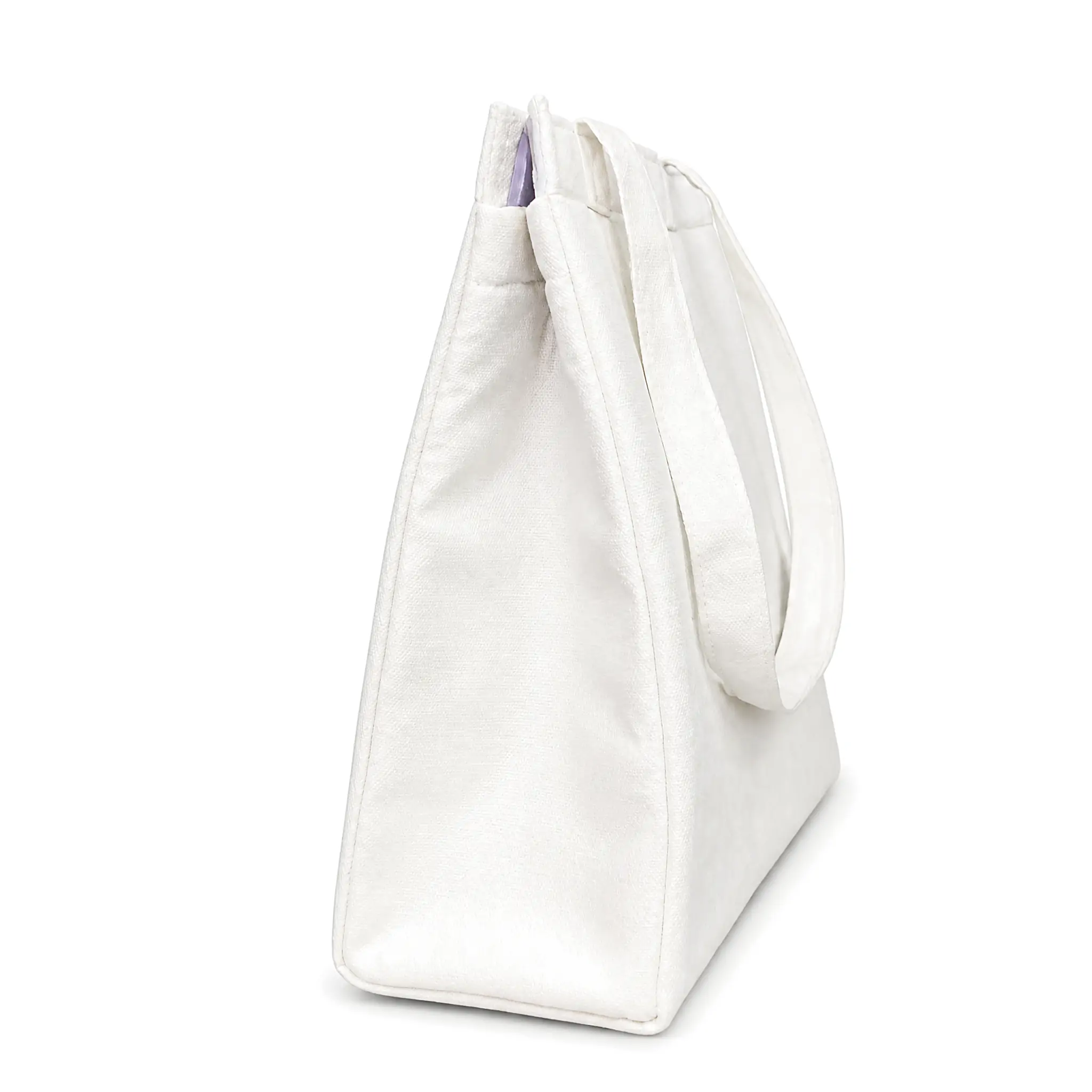 White 10oz canvas insulated lunch bag 25 x 30 x 12 cm with self-fabric handles and a top zipper, standing upright on a wooden desk beside a coffee cup and a sandwich plate